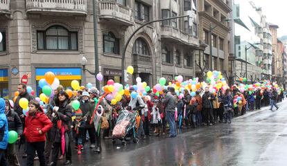 Cientos de niños portan globos para la suelta por la paz.