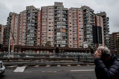 Un hombre pasa ante un edificio de viviendas en la localidad lombarda de Sesto San Giovanni.