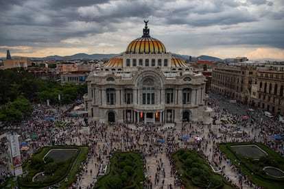 Asistentes a la marcha se congregan alrededor del Palacio de Bellas Artes en su paso hacia el Zócalo de Ciudad de México. 