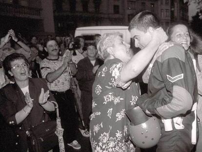 Una mujer abraza a uno de los <i>ertzaina</i>s que se quitaron la capucha en la sede de HB tras el asesinato de Miguel Ángel Blanco.
