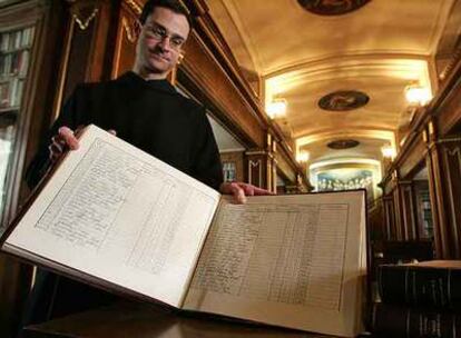 Un benedictino muestra uno de los registros de restos.