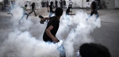 Un manifestante lanza un bote de gas a los antidisturbios durante una protesta en Manama.