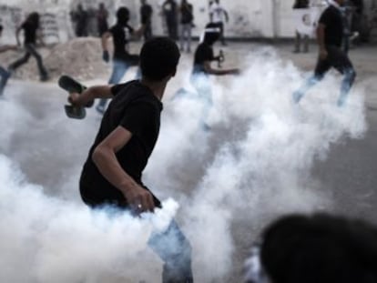 Un manifestante lanza un bote de gas a los antidisturbios durante una protesta en Manama.