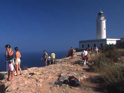 Excursionistas junto al faro de La Mola, en el extremo este de la isla de Formentera.