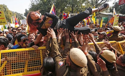 Una joven tibetana intenta cruzar una barricada de la Policía durante una protesta para conmemorar el 60 aniversario del levantamiento tibetano contra el gobierno chino, frente a la embajada china en Nueva Delhi (India).