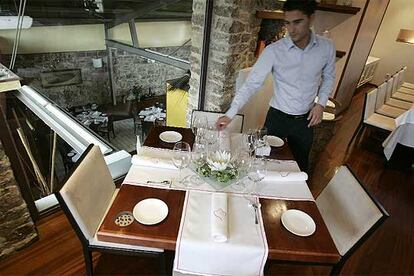 Comedor superior del restaurante Koldo Miranda, en Castrillón, Asturias. Abajo, el cocinero preparando un plato.