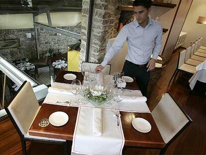 Comedor superior del restaurante Koldo Miranda, en Castrillón, Asturias. Abajo, el cocinero preparando un plato.