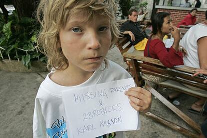 El niño sueco Karl Nilsson, en Phuket, con un cartel en el que puede leerse: "Padres y dos hermanos desaparecidos".