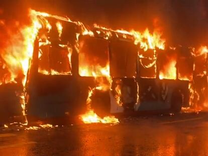 Un autobús arde en llamas a las afueras del Liceo de Aplicación, en Santiago, este jueves, en una imagen compartida en redes sociales.
