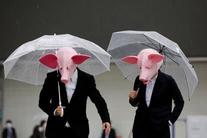 Dos 'youtubers' disfrazados con máscaras de cerdos durante una grabación en el distrito financiero de Tokio (Japón).