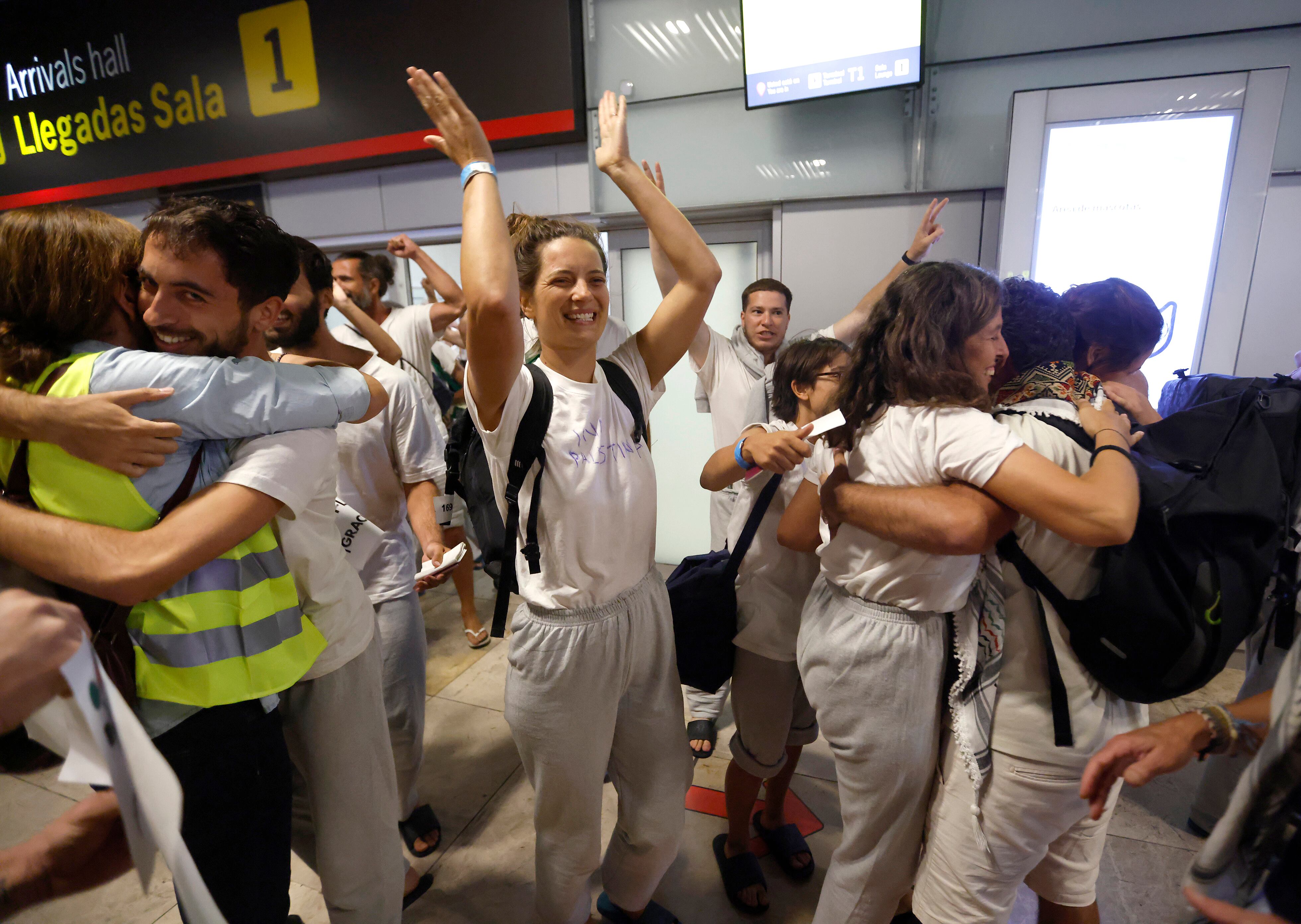 Los españoles deportados por Israel se abrazan a sus familiares y amigos este domingo en el aeropuerto de Madrid-Barajas.