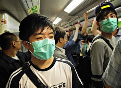 Dos ciudadanos chinos viajan con mascarilla en el metro de Hong Kong