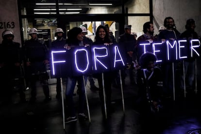Un grupo de protestantes sostiene pancartas en las que se puede leer 'Fora Temer' (Fuera Temer), frente a la policía militar en Sao Paulo.