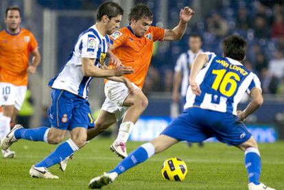 El jugador del Málaga Seba trata de escapar de Javi López y el argentino Forlín, del Español, durante el partido de la décima jornada de Liga.