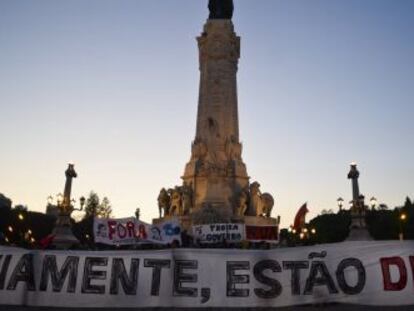 Manifestantes sujetan una pancarta que reza: "Obviamente, estáis cesados" en la plaza del Marqués de Pombal en Lisboa.