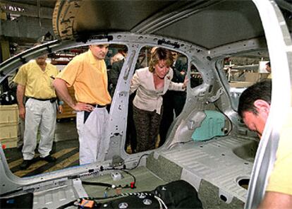 Esperanza Aguirre revisa el interior de un coche en la cadena de montaje de la factoría Peugeot en Villaverde.
