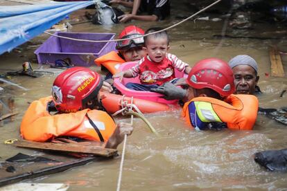 Las personas fallecidas murieron ahogadas, por hipotermia o arrastradas por los deslizamientos de tierra. Entre las víctimas están un niño de 8 años y un adolescente de 16, según relata la agencia France Presse. En la imagen, un niño es socorrido por los servicios de rescate en Yakarta.