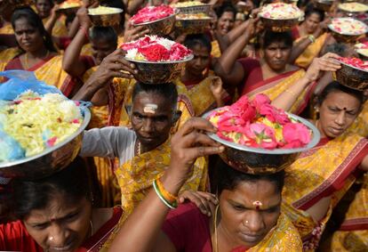 Mujeres indias llevan flores al mar para lanzarlas como ofrenda durante una ceremonia por las víctimas del tsunami en la playa de Pattinapakkam en 2004, en Chennai (India).
