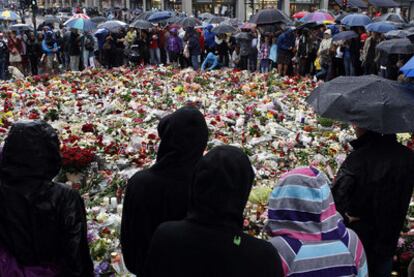 Decenas de personas se congregan en el exterior de la catedral de Oslo, en torno a ofrendas de flores y velas en memoria de las víctimas.