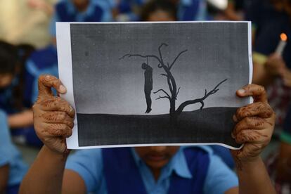 Una niña sostiene una imagen que muestra a un joven ahorcado en un acto de protesta en un colegio de Ahmedabad. Numerosos colectivos han pedido en las últimas semanas un endurecimiento del código penal contra los agresores sexuales en India.