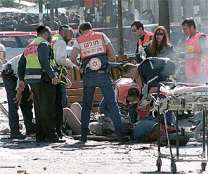 Los servicios de emergencia atienden a un herido del atentado suicida registrado ayer en el centro de Tel Aviv.