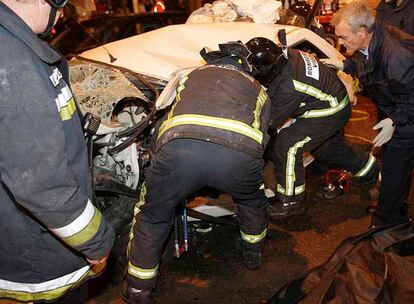 Los bomberos tratan de rescatar los cuerpos del matrimonio fallecido.