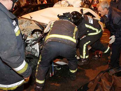 Los bomberos tratan de rescatar los cuerpos del matrimonio fallecido.