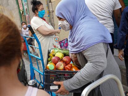 Entrega de alimentos a personas necesitadas en la Asociación Valiente Bangla del barrio de Lavapiés.