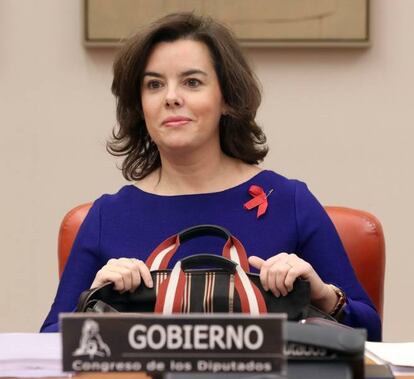 La vicepresidenta del Gobierno, Soraya Sáenz de Santamaría, después de ponerse un lazo rojo, en el Día Mundial contra el Sida, antes de su comparecencia ante la Comisión Constitucional del Congreso para dar cuenta de sus prioridades en el Ejecutivo, una vez que ha asumido la relación con las autonomías y, en ese entorno, el desafío soberanista catalán.