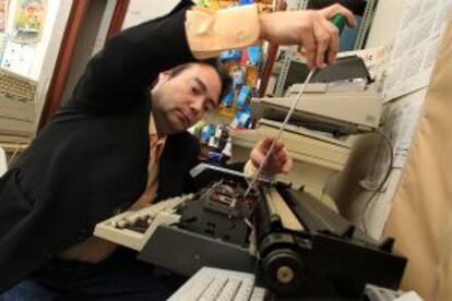 Un trabajador de Maquinas Montilla arregla una máquina de escribir.
