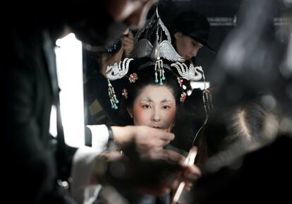 Una mujer es maquillada en el backstage antes de participar en un espectáculo del diseñador Chu Yan durante la semana de la moda de Chinat China en Pekín.