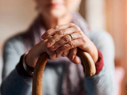 Un anciana se apoya sobre su bastón.