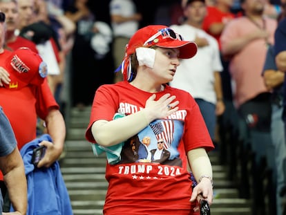 Varios asistentes se llevan la mano al pecho durante un mitin de Trump y Vance.