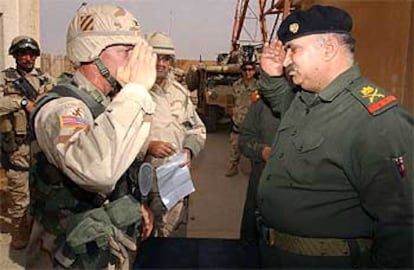 El coronel de EE UU Curtis Potts (izquierda), saluda al general iraquí Mohamed Jaraui, tras firmar éste su rendición