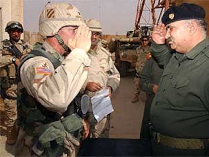 El coronel de EE UU Curtis Potts (izquierda), saluda al general iraquí Mohamed Jaraui, tras firmar éste su rendición