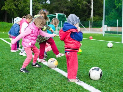 Varios niños juegan al fútbol. 