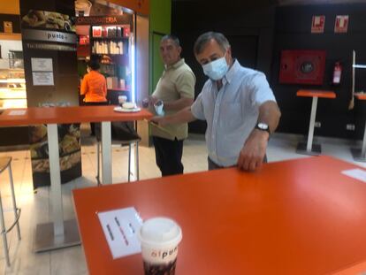 El dueño de la panadería y cafetería de la estación de Moncloa organiza las mesas según las medidas de seguridad.