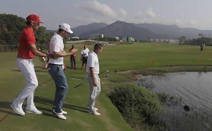 Cabrera, de rojo, el austriaco Wiesberger y Sergio García interrumpen su ronda de entrenamiento en Marapendi para observar a un capibara en la laguna.