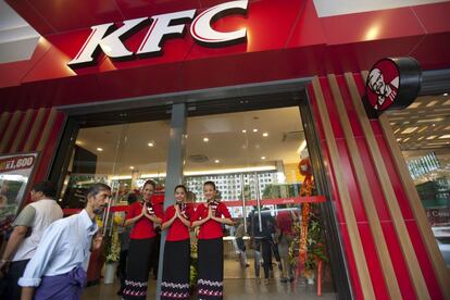 Empleadas del nuevo establecimiento de la multinacional de pollo frito KFC Chicken dan la bienvenida a los clientes el pasado 30 de junio en Yangon.
