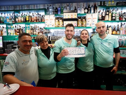 Miembros del personal de la cafetería Calusa, en Las Cabezas de San Juan (Sevilla), posan tras haber repartido 3,5 millones en 140 décimos agraciados con el tercer premio del sorteo de El Niño, el 18.918, un número que llevan trece años jugando porque es "el número del local".