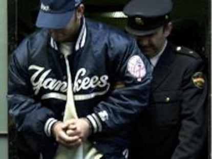 James Anglada escoltado por un policía.