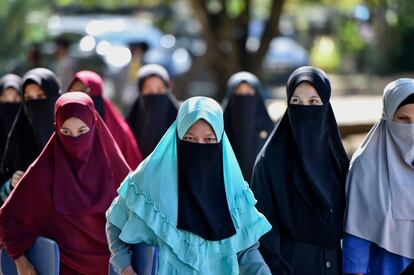 Varias estudiantes de un internado se desplazan para hacerse una prueba del coronavirus, en Sibreh (Indonesia).  