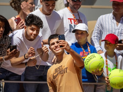 Alcaraz se hace un selfie con un aficionado durante un entrenamiento en la Philippe Chatrier.