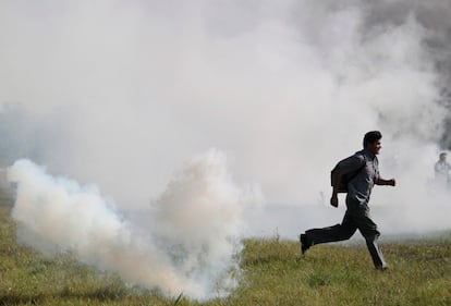 Un boliviano procedente del Territorio Indígena y Parque Nacional Isiboro-Secure (TIPNIS) escapa de los gases lacrimógenos lanzados por la policía en el aeropuerto.