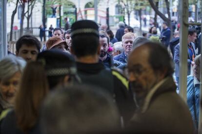 Un agent regula la cua d'entrada a l'escola Ausis March de Barcelona.