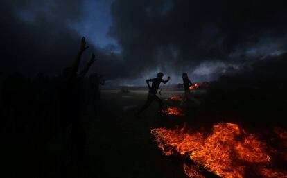 Manifestantes palestinos corren del gas lacrimógeno lanzado por los soldados israelíes, en la Franja de Gaza.  