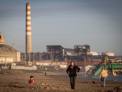 Personas en la Playa Ventanas, en la región de Valparaíso (Chile), junto a una de las fábricas del cordón industrial de la zona.