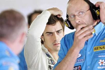 Fernando Alonso rodeado de miembros de su equipo durante los entrenamientos del GP de España.