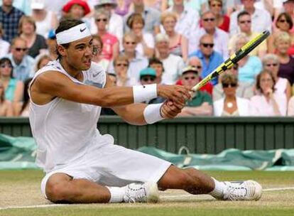 Rafael Nadal devuelve desde la hierba una pelota a Roger Federer.