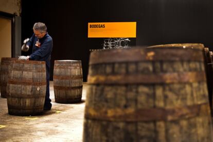 Un tonelero de Destilerías DYC repara una barrica de roble americano en la bodega.